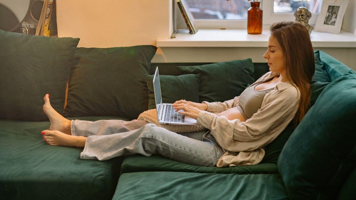 Woman relaxing on the couch while looking at a computer